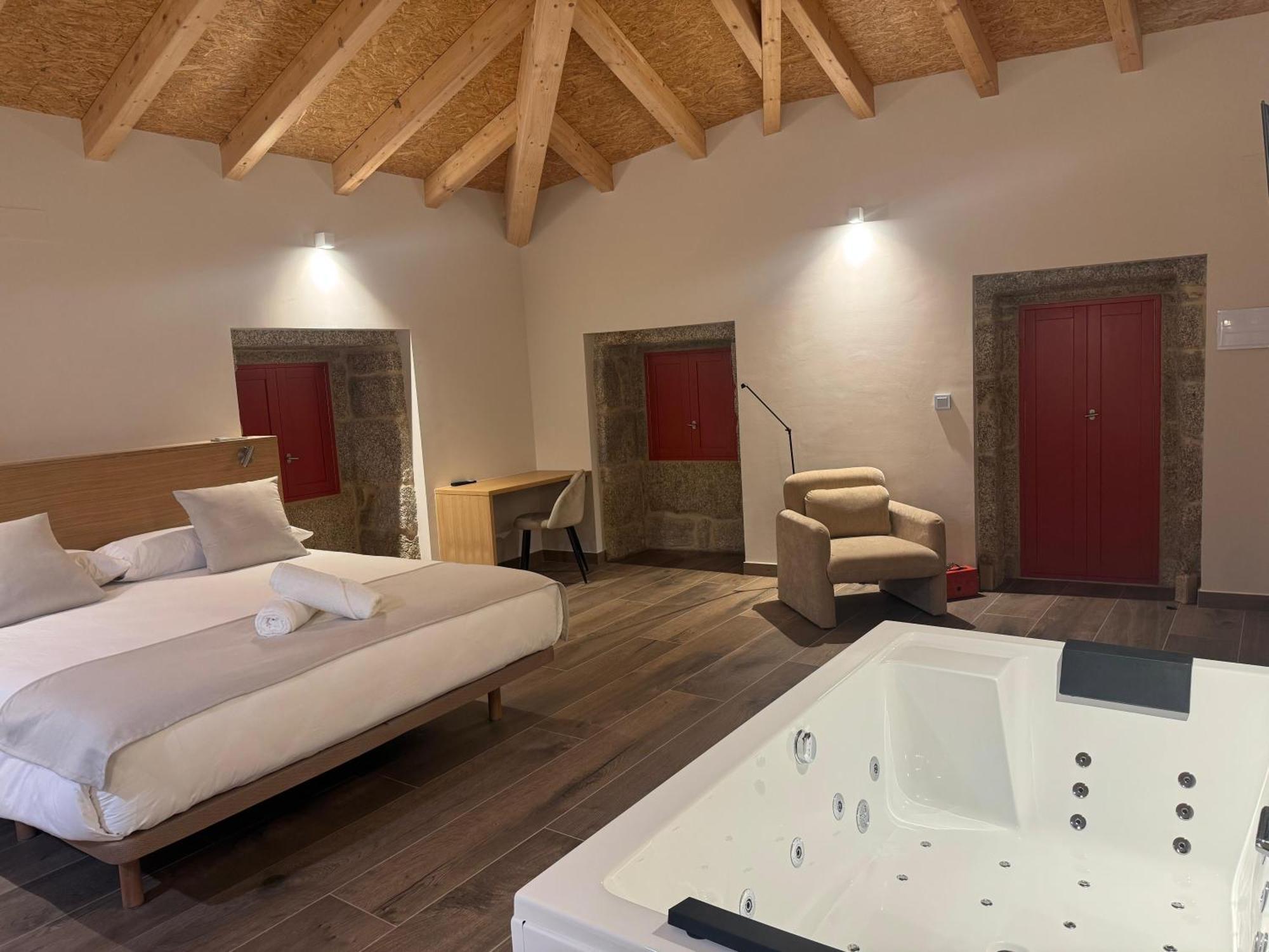 Habitación con cama grande y bañera de hidromasaje